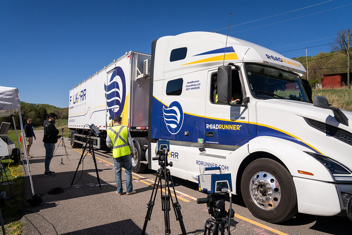Researchers instrumenting a heavy truck with cameras and sensors at a VTTI roadside test site